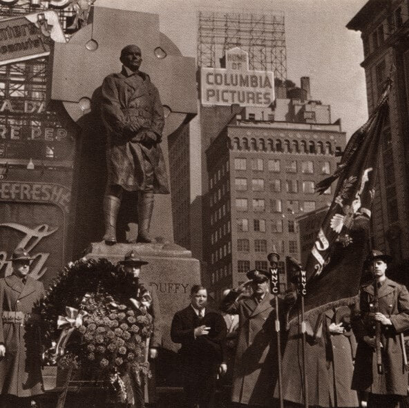 Which priest has a statue in Times Square?