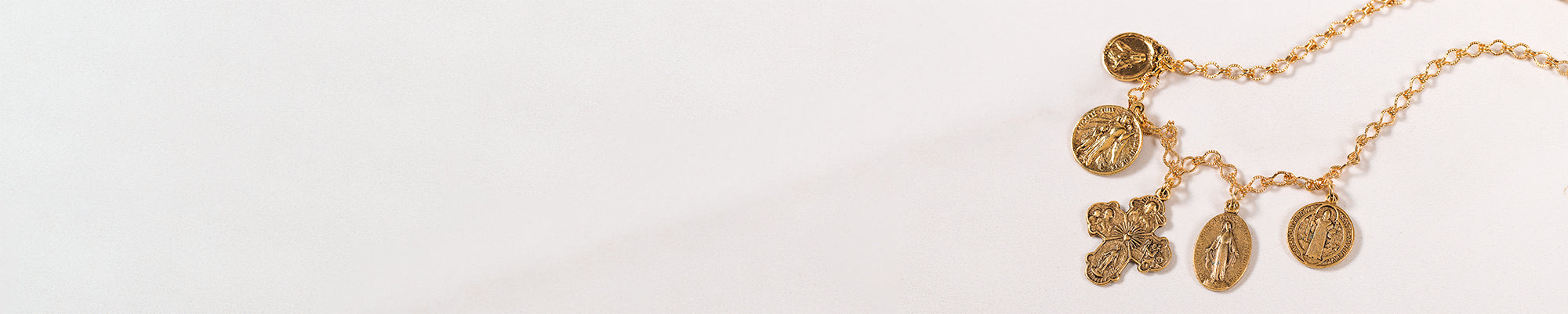 Catholic jewelry piece with cross and pendants on white backdrop