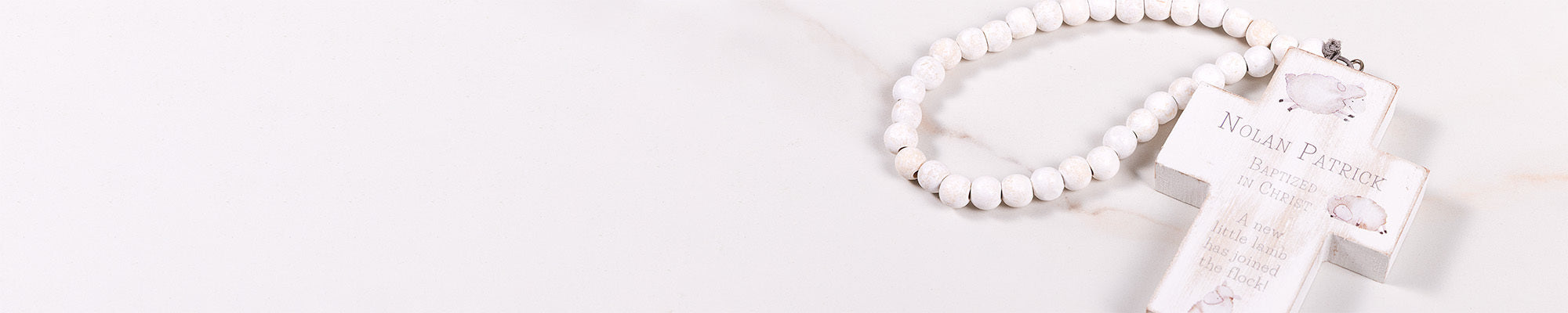 Banner image for Catholic sacramental gifts featuring white wooden rosary and cross