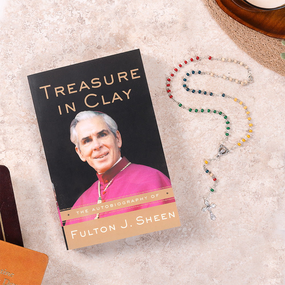 Book titled 'Treasure in Clay' by Fulton J. Sheen with a rosary on a textured surface