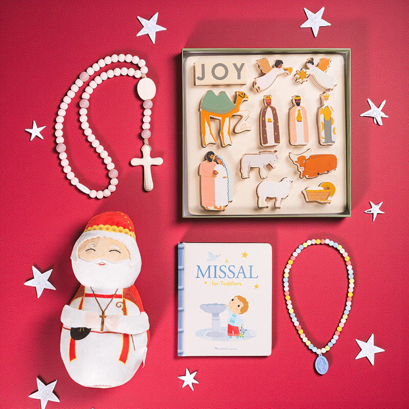 Collection of religious items including a rosary, nativity scene cookies, a Santa figurine, and a missal on a red background with stars.