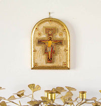 Decorative wall hanging with a cross and figure on a white background.