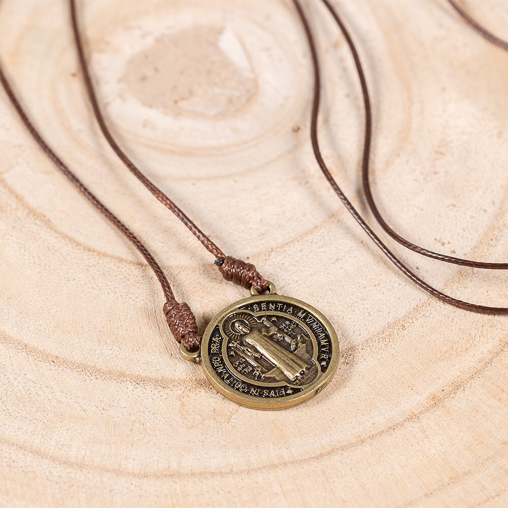 Saint Benedict medal necklace with brown cord and antique bronze finish.