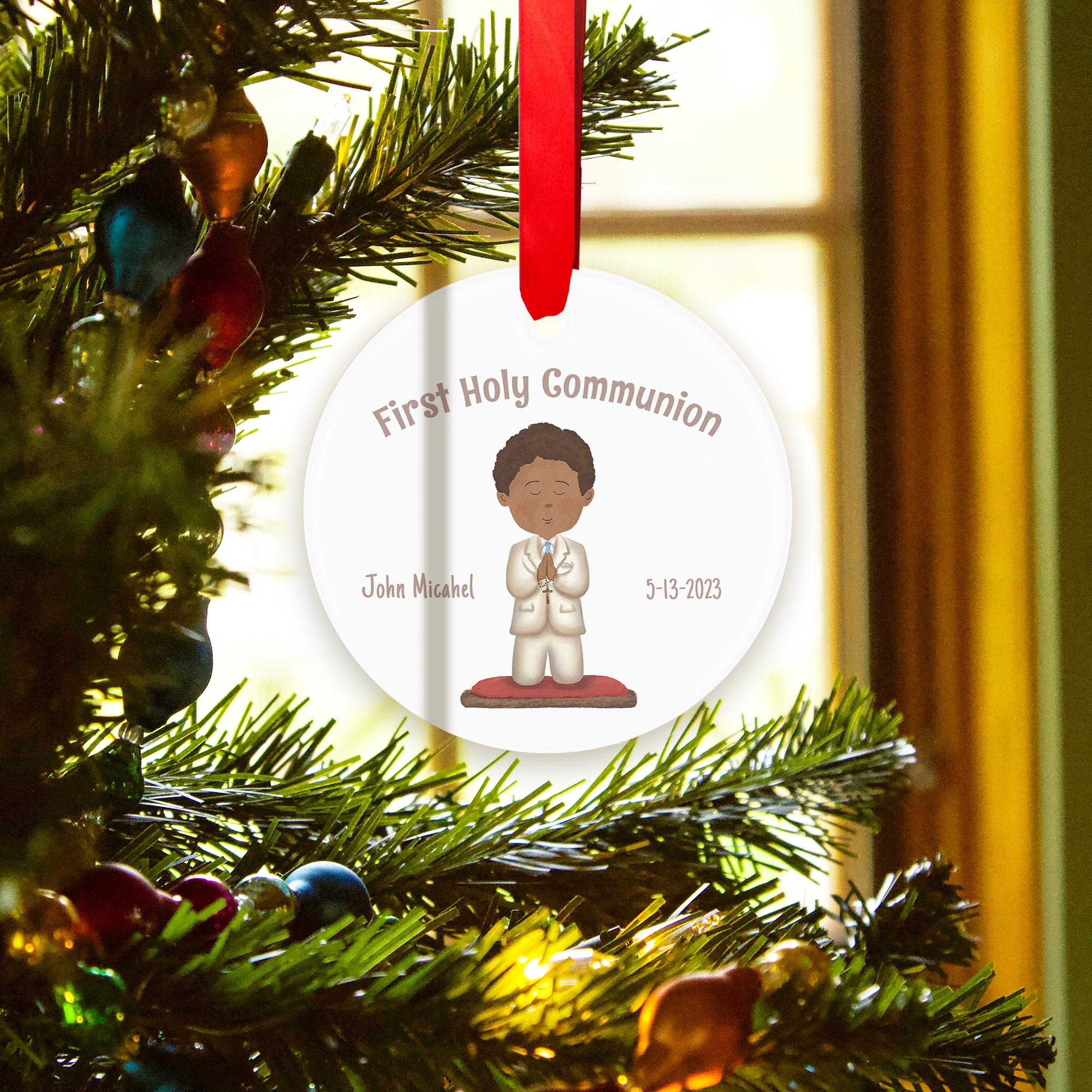 White, round ceramic First Holy Communion ornament with a red ribbon.
