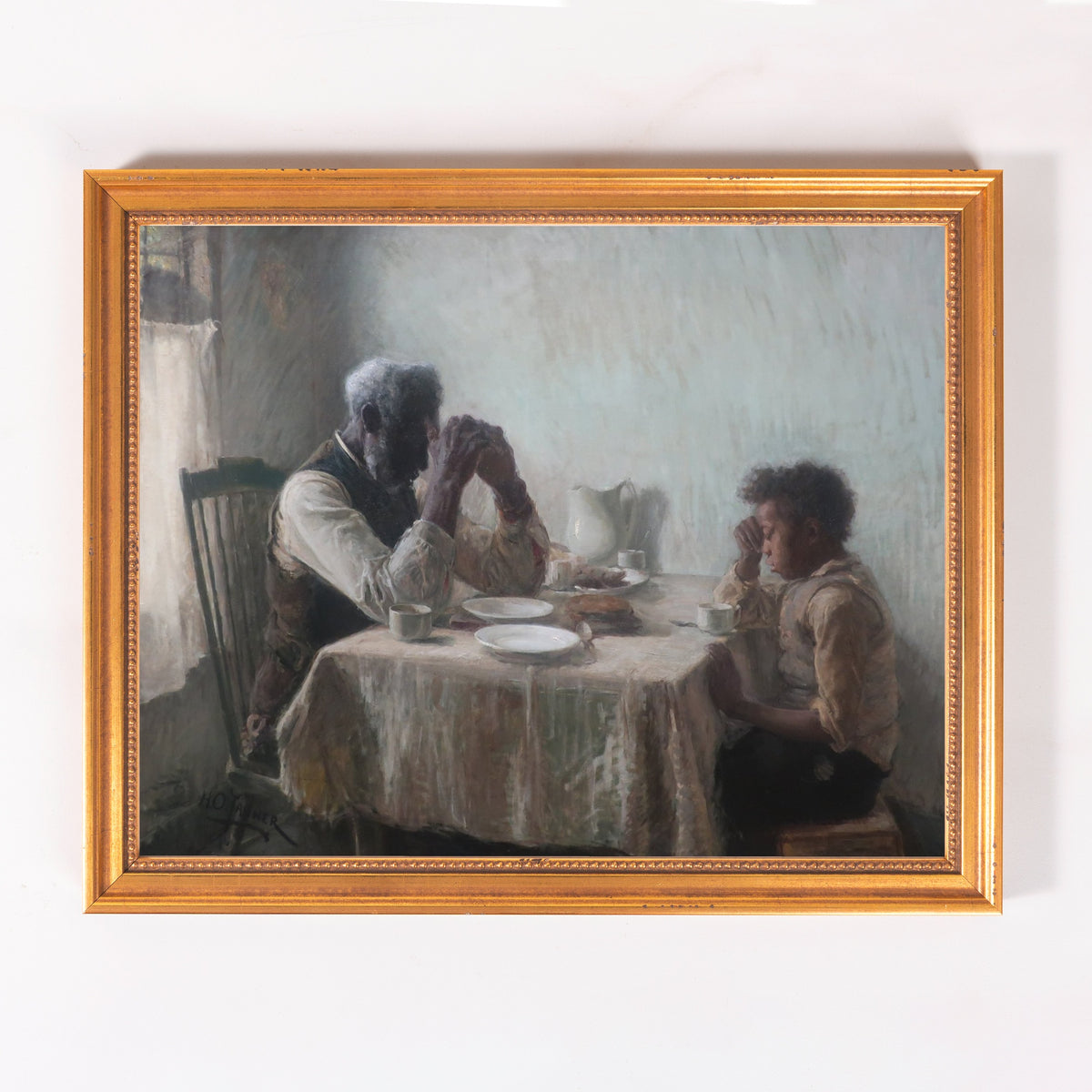 Framed oil painting of two people praying at a table, in muted beige, grey, and gold tones.