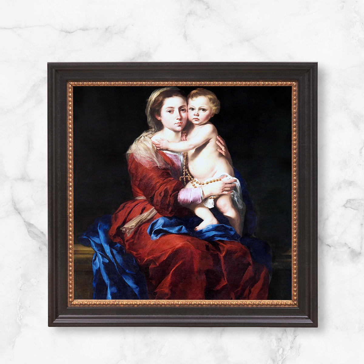 Framed print of Mary and Jesus with dark wood frame and golden beaded trim.