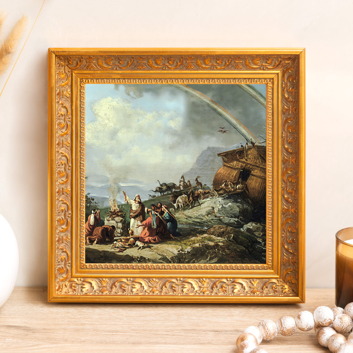 Framed print of Noah's Ark with a gold, ornate frame on a light wood table.