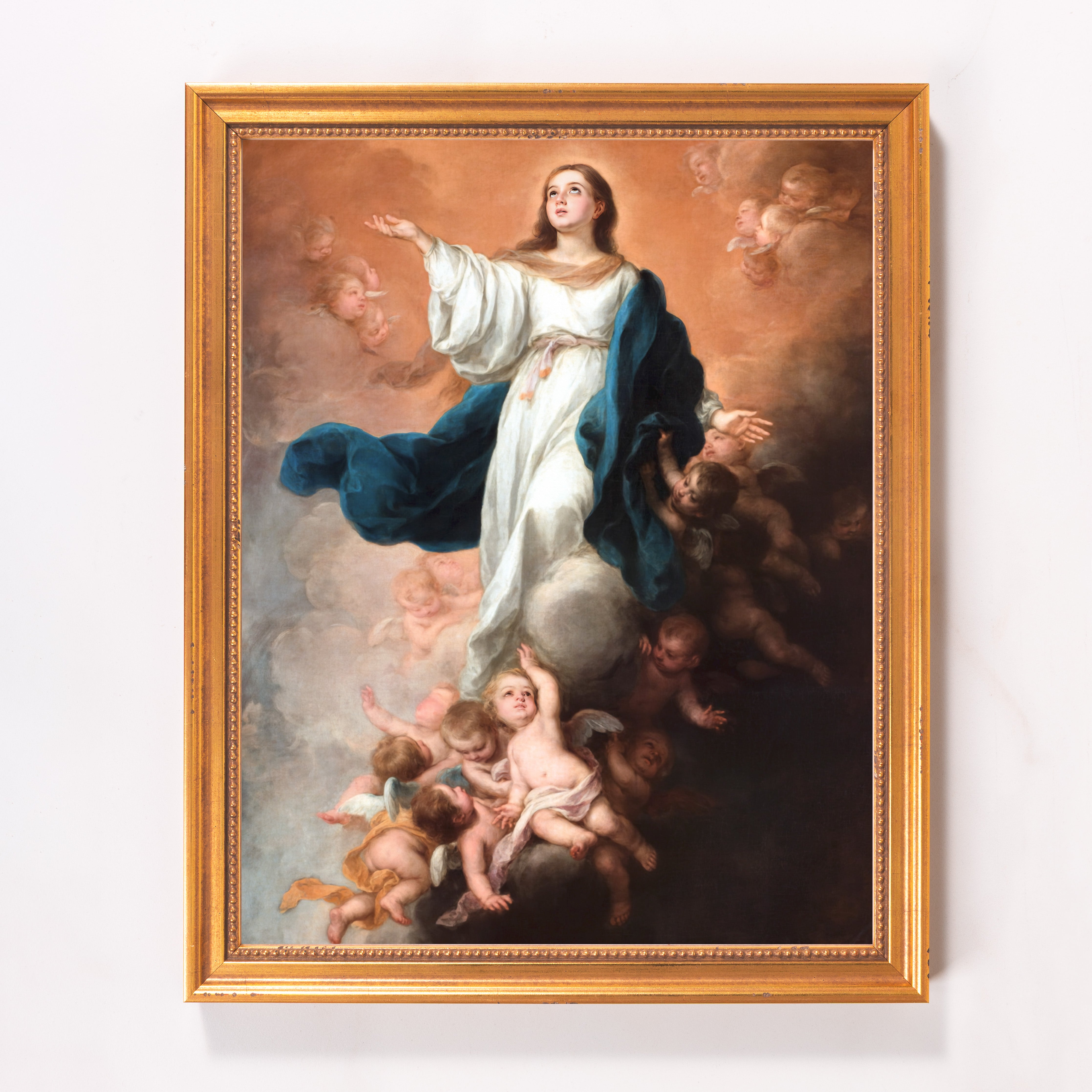 Framed painting of the Virgin Mary rising to heaven surrounded by angels in a gold frame.