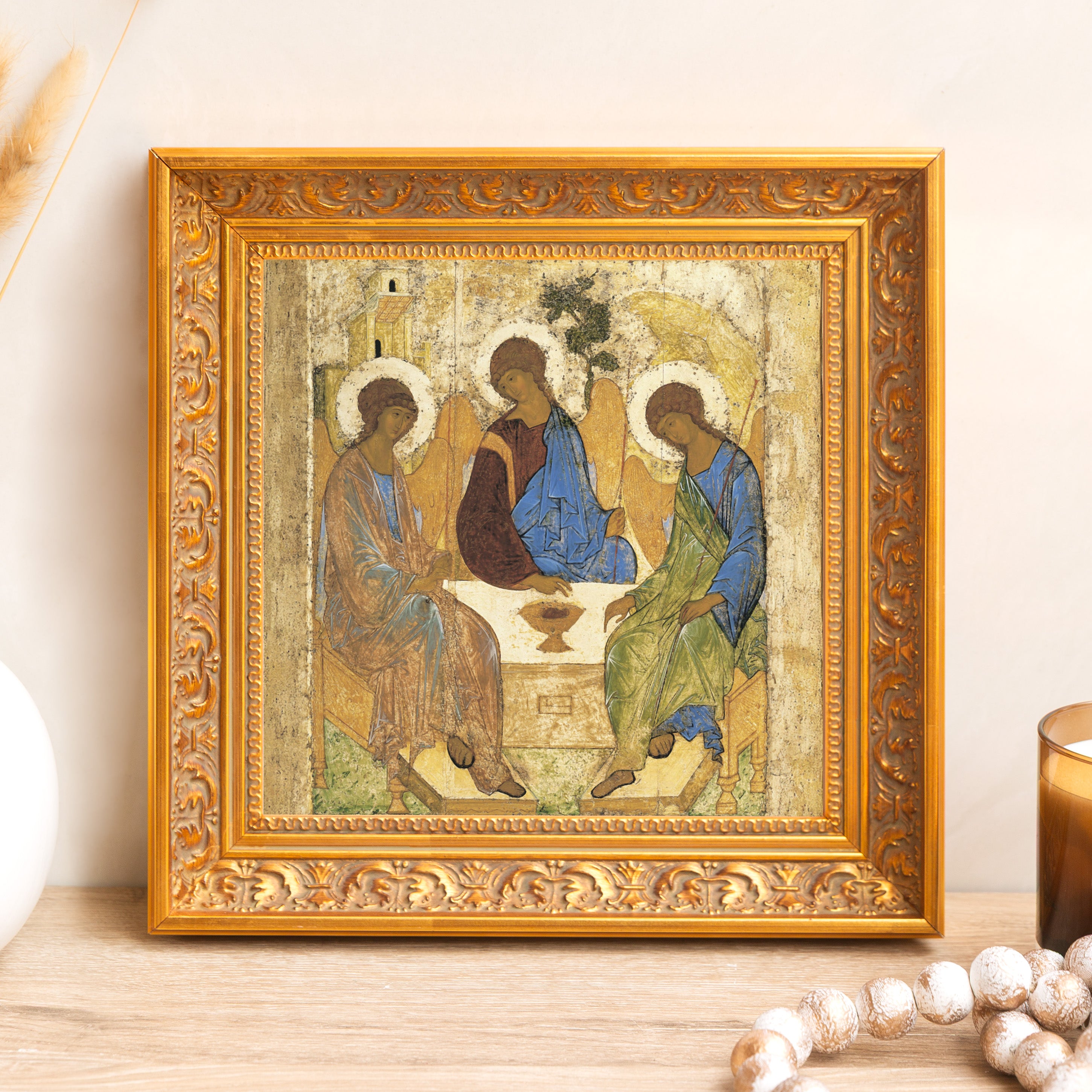 Framed, Russian Orthodox icon print depicting the Holy Trinity in gold, blue, and brown hues.