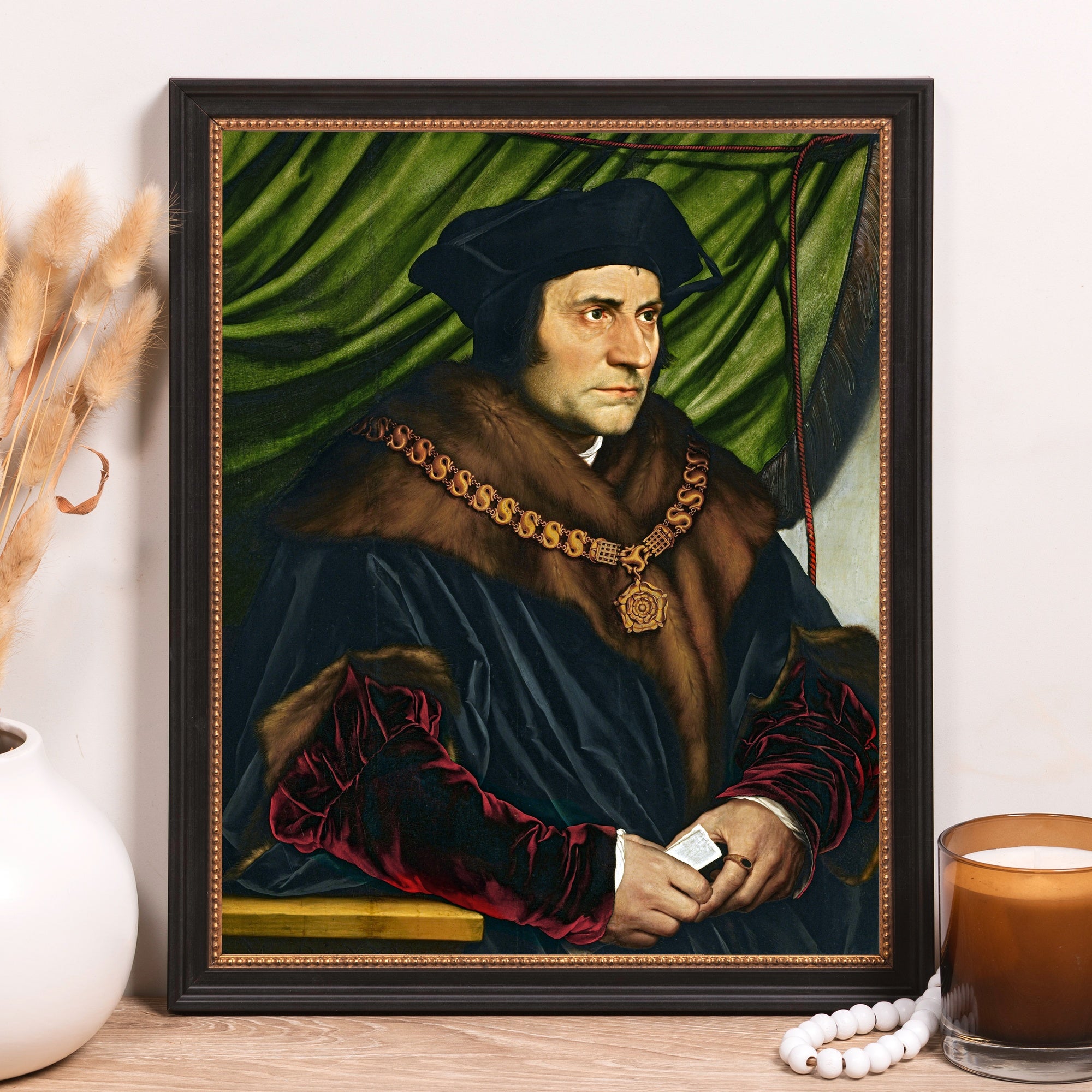 Framed, Black-Hatted Portrait of a man in fur-trimmed robes with gold chain against a green backdrop in a dark frame.