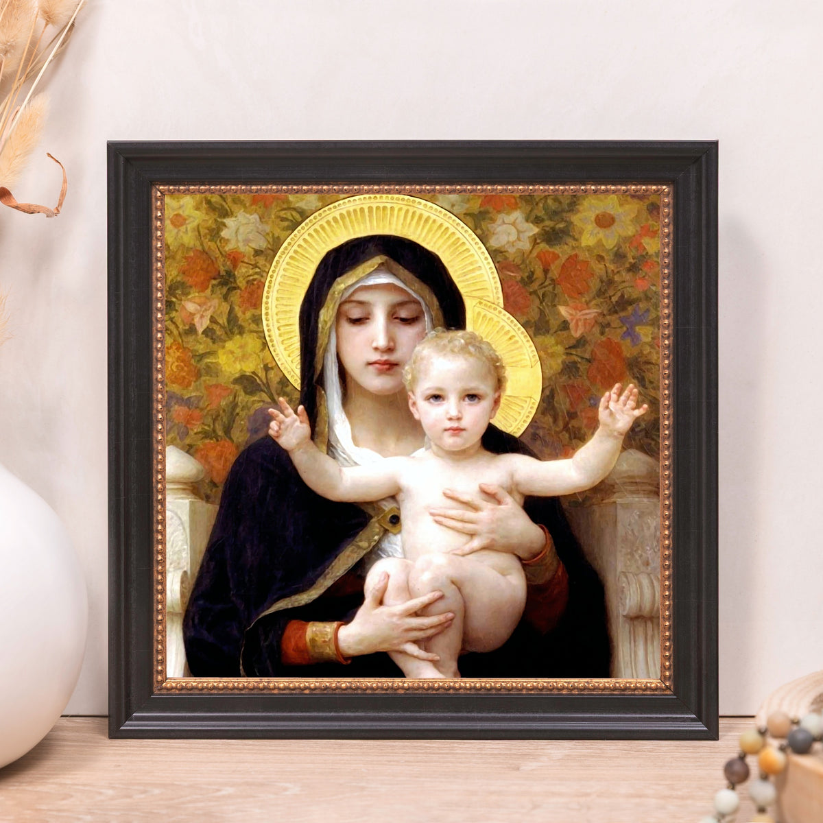 Framed oil painting of Mary and Jesus with gold halo, dark navy robe, and floral background in black frame.