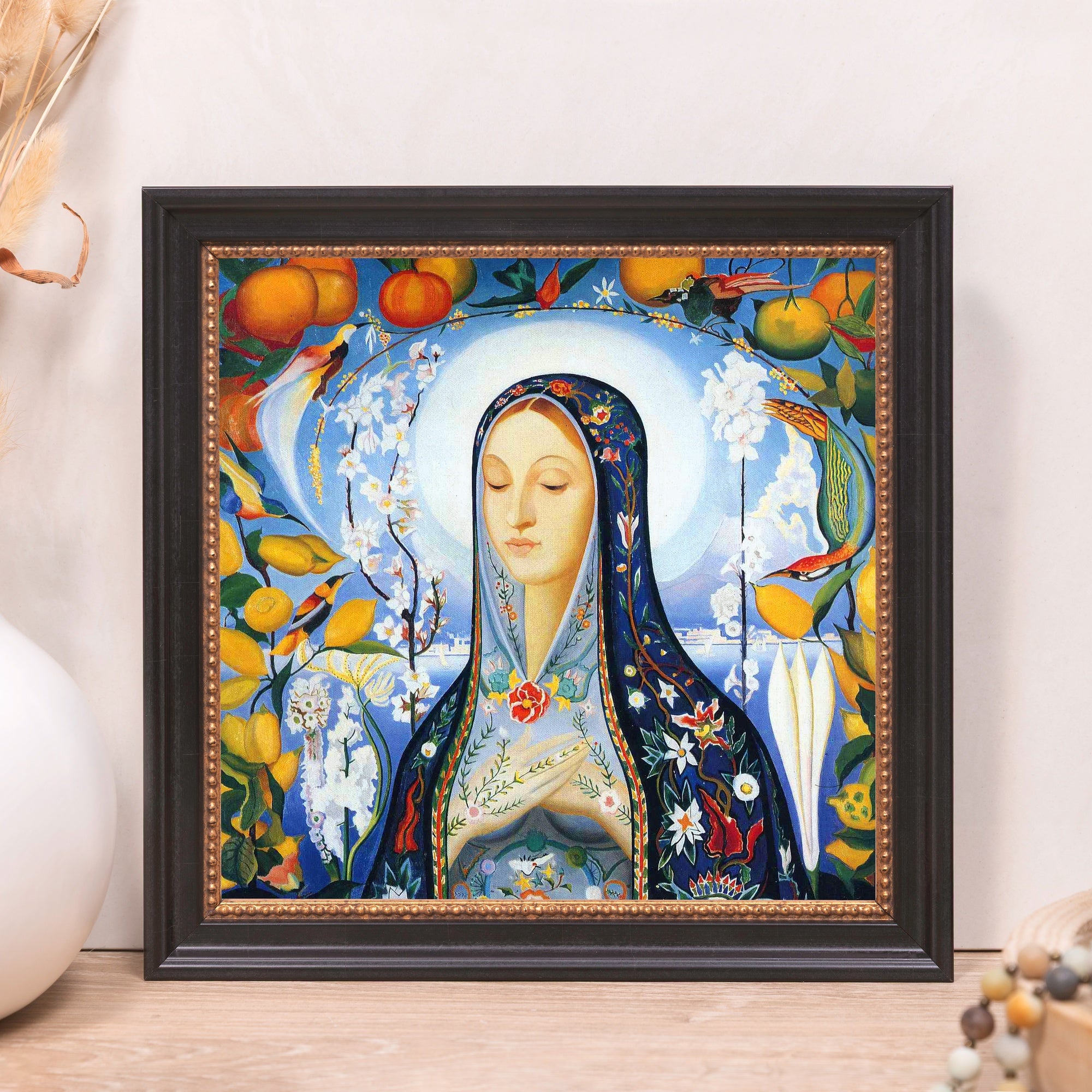 Framed art print of woman in blue robe with flower and bird details, dark frame.
