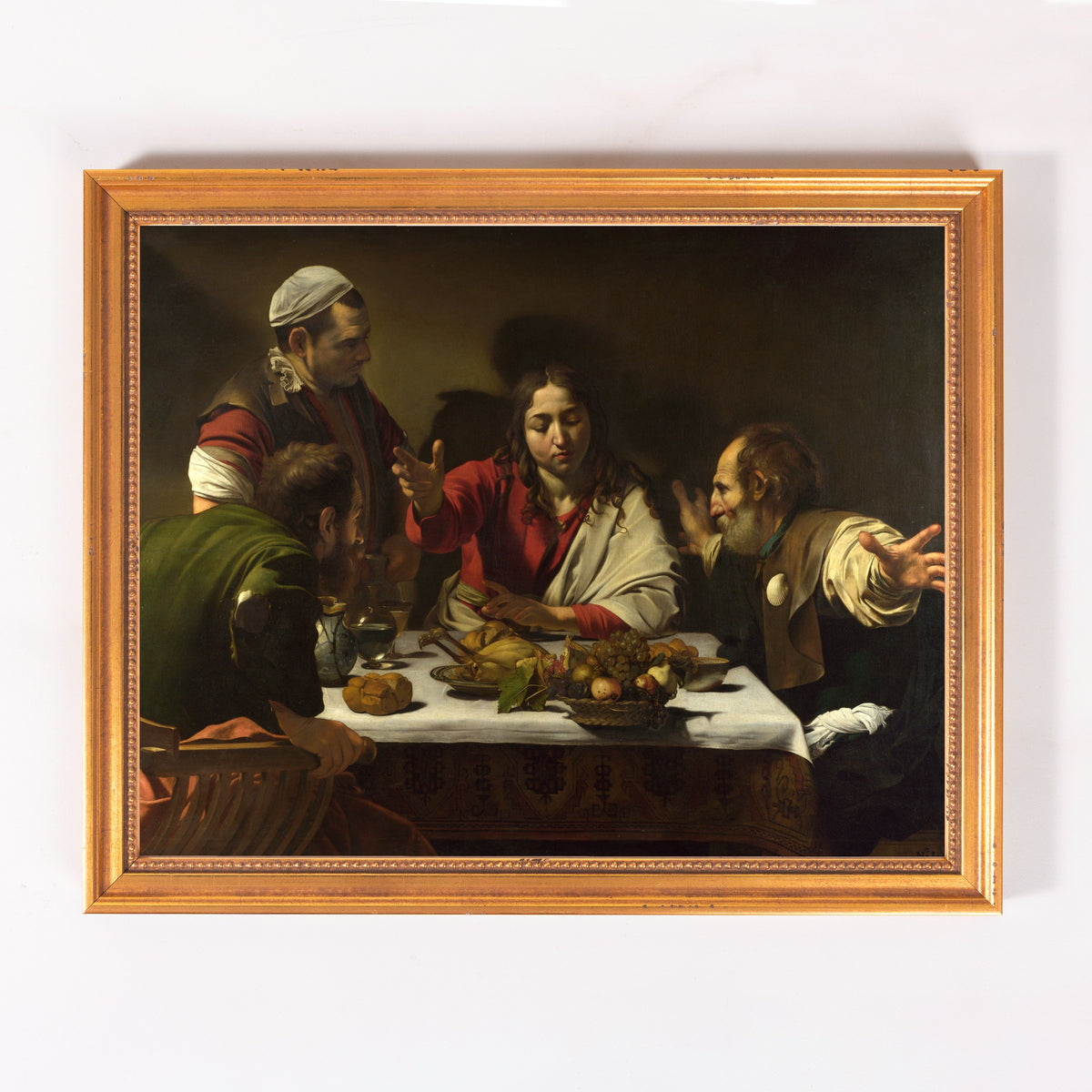 Framed painting of "The Supper at Emmaus" in a baroque style with a gold frame.