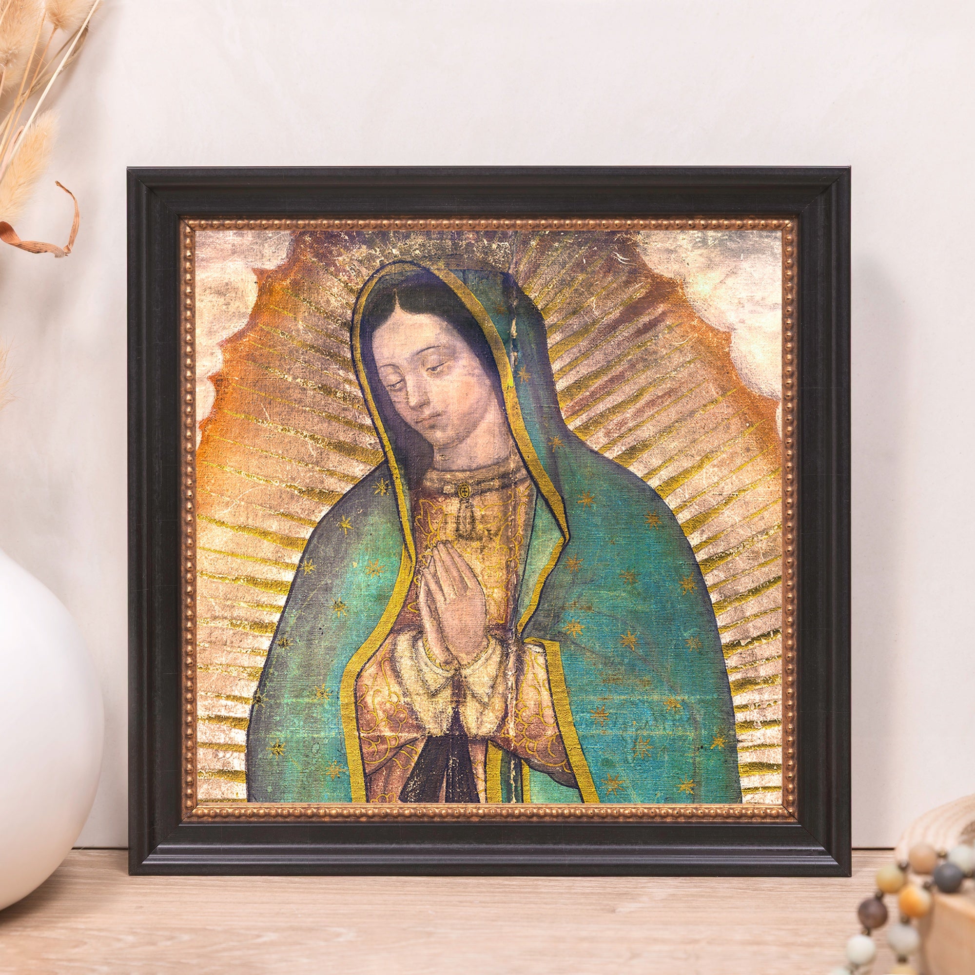 Framed Our Lady of Guadalupe wall art with black frame and gold detailing.