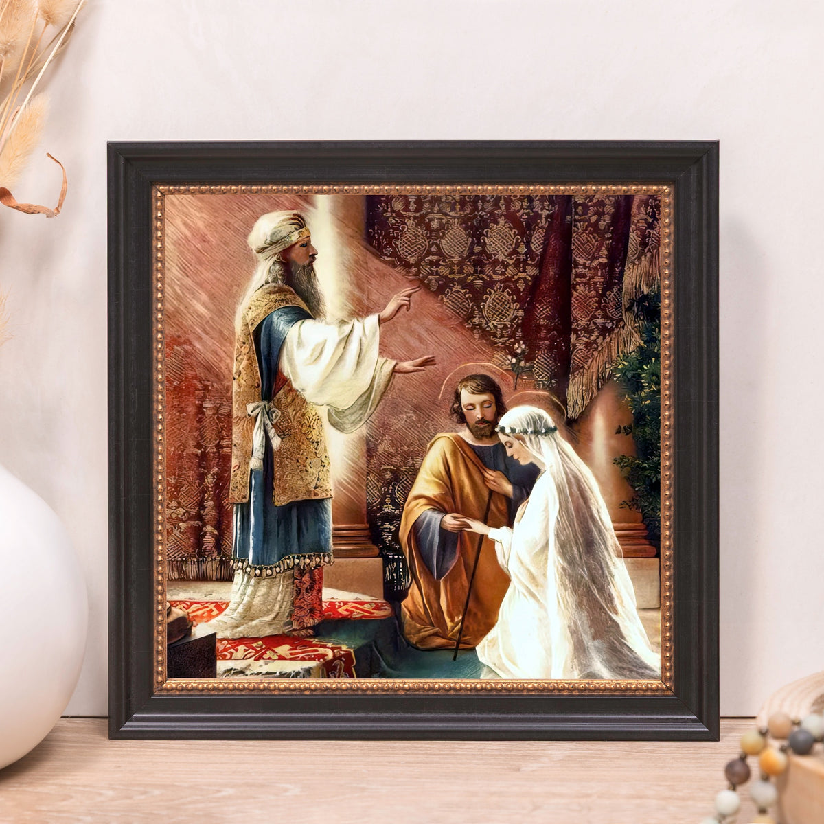 Framed marriage art, depicting a religious ceremony, gold tones with a black frame.