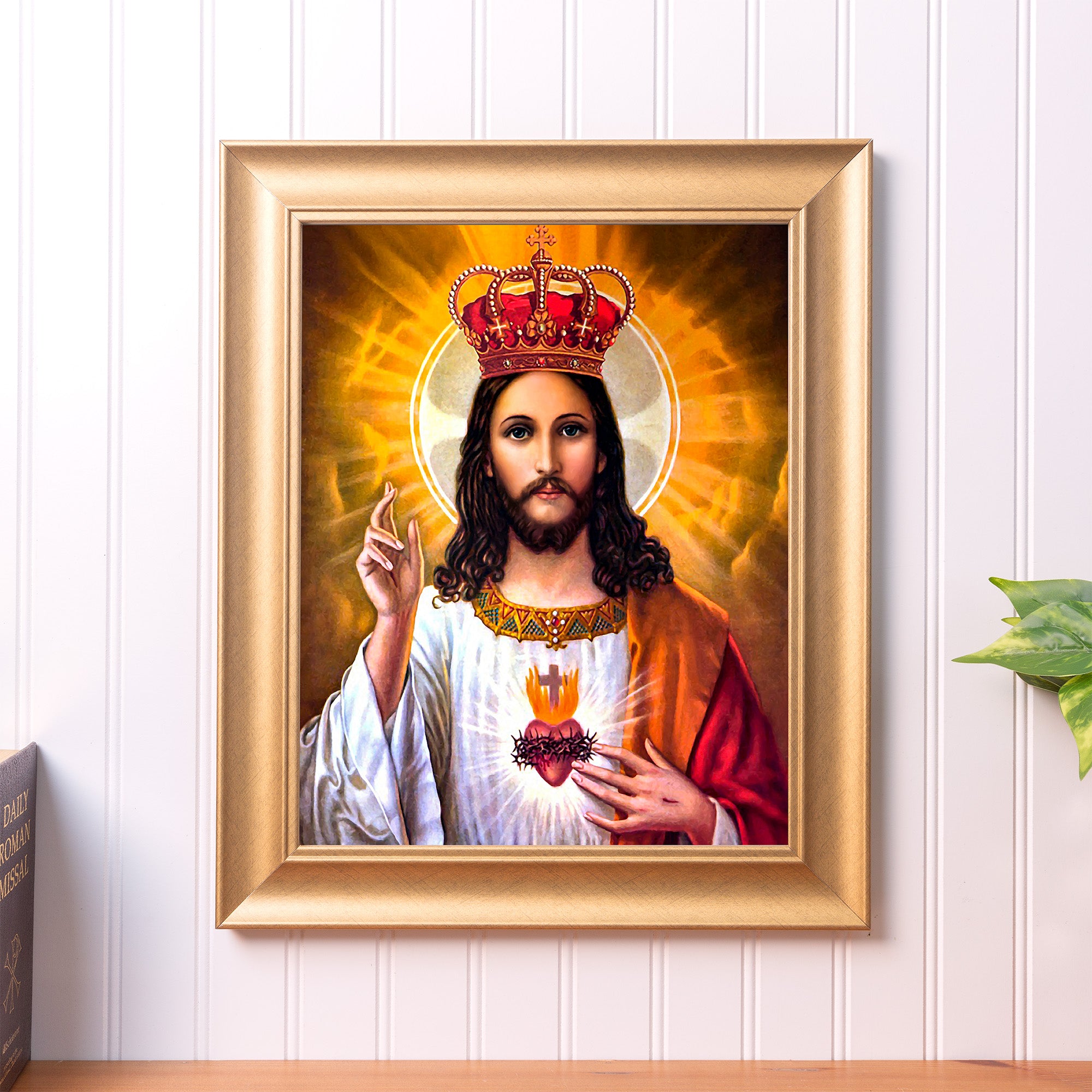 Framed image depicting Jesus with crown, robe, and sacred heart emblem; gold frame.
