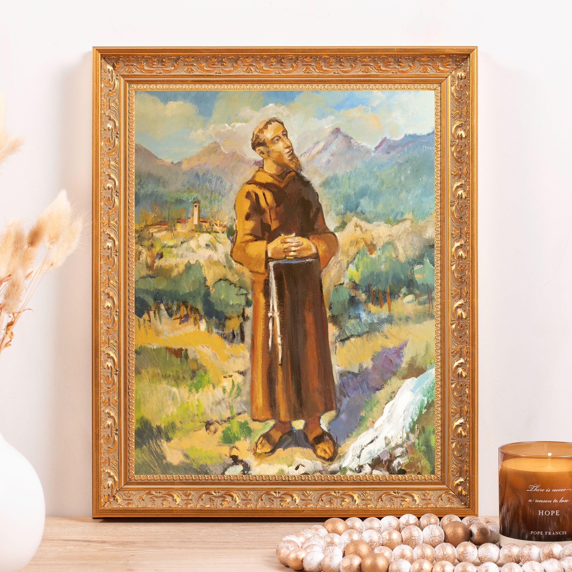 Framed painting depicting a friar in brown robes, ornate gold frame.