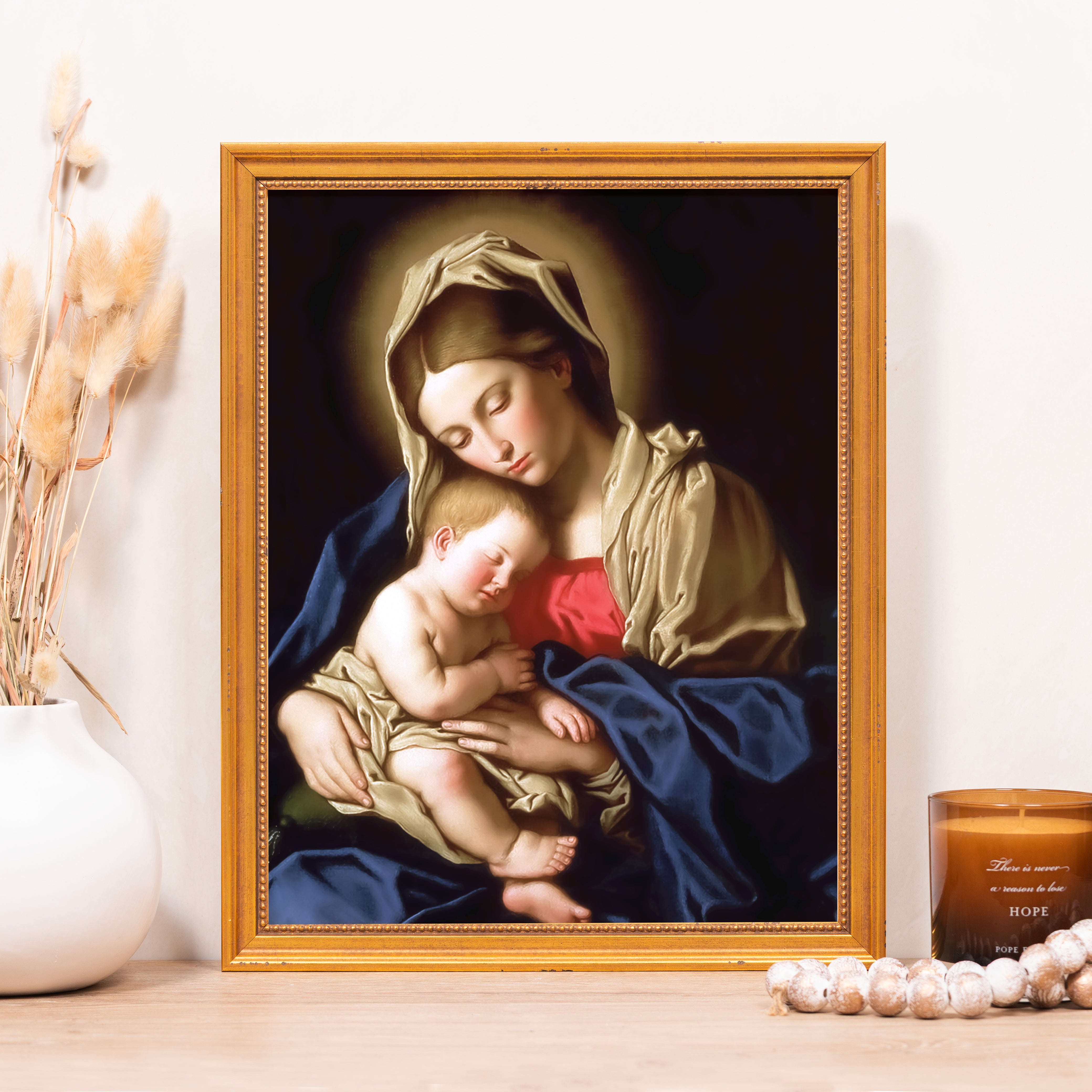 Framed art of Mary and Baby Jesus with a blue robe and gold frame.