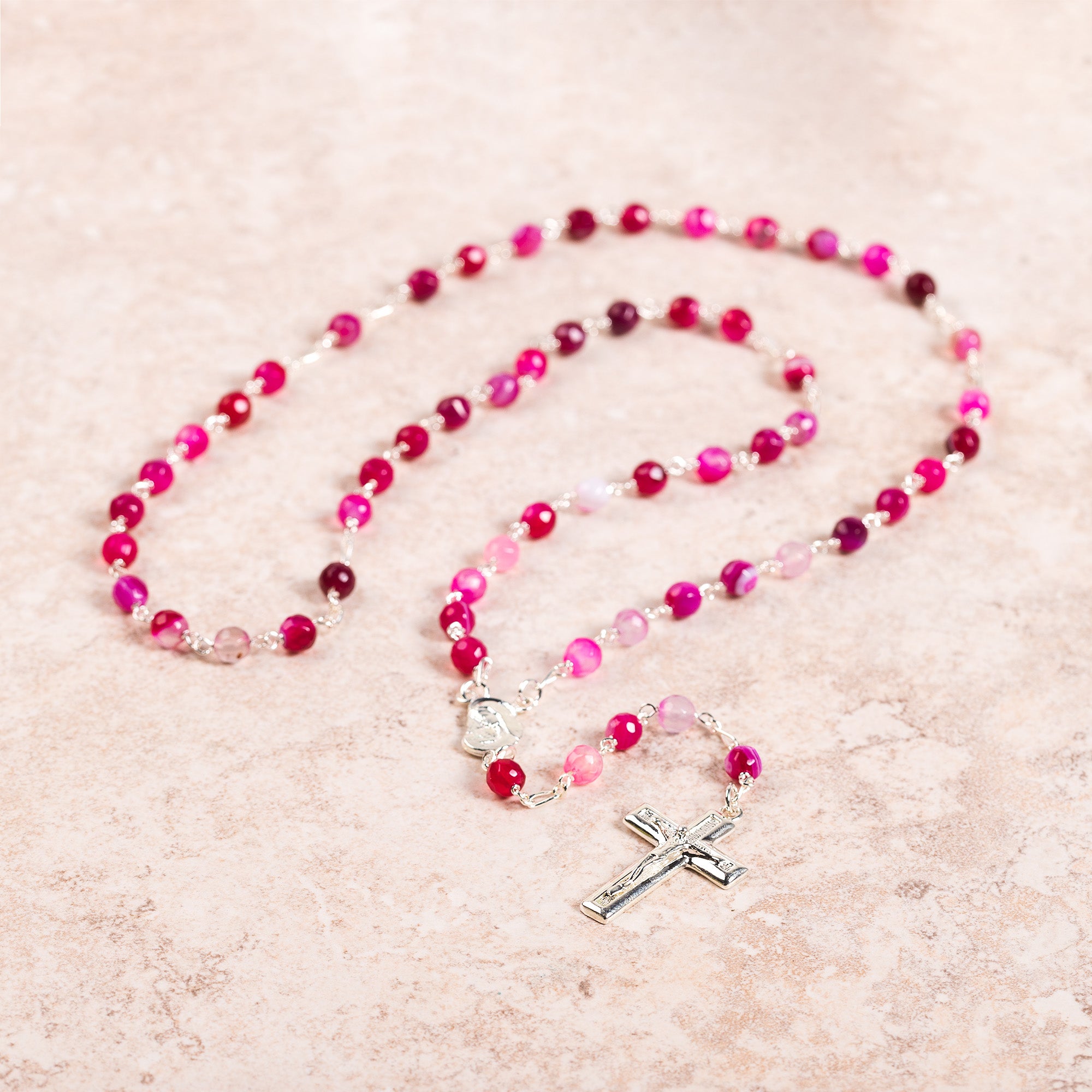 Rosary with pink agate beads and silver crucifix.