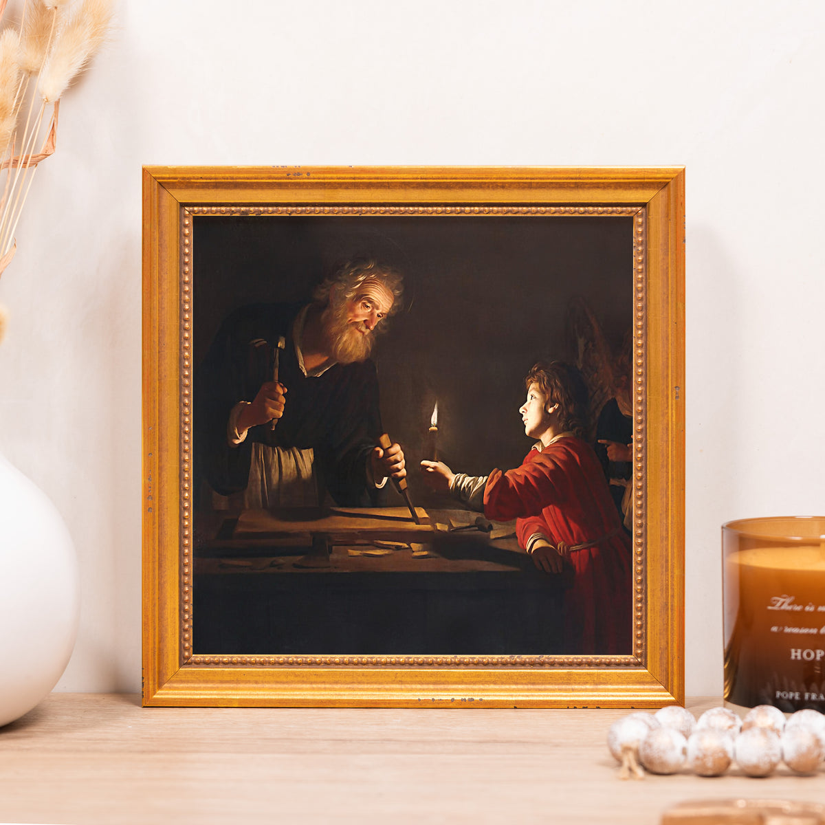 Framed painting of Saint Joseph at work with gold frame.