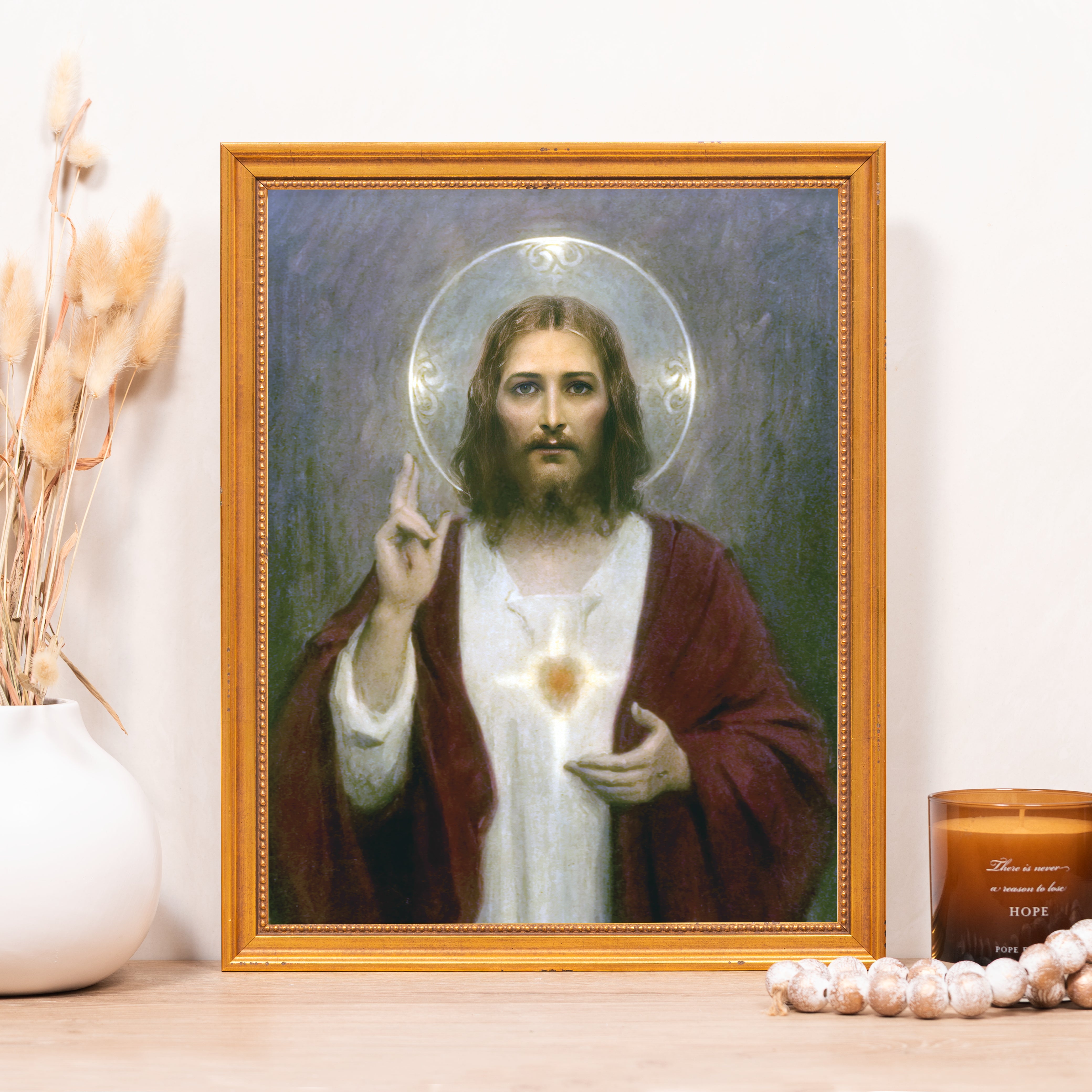 Framed Portrait of Jesus Christ with a golden frame and white robe over maroon robe.