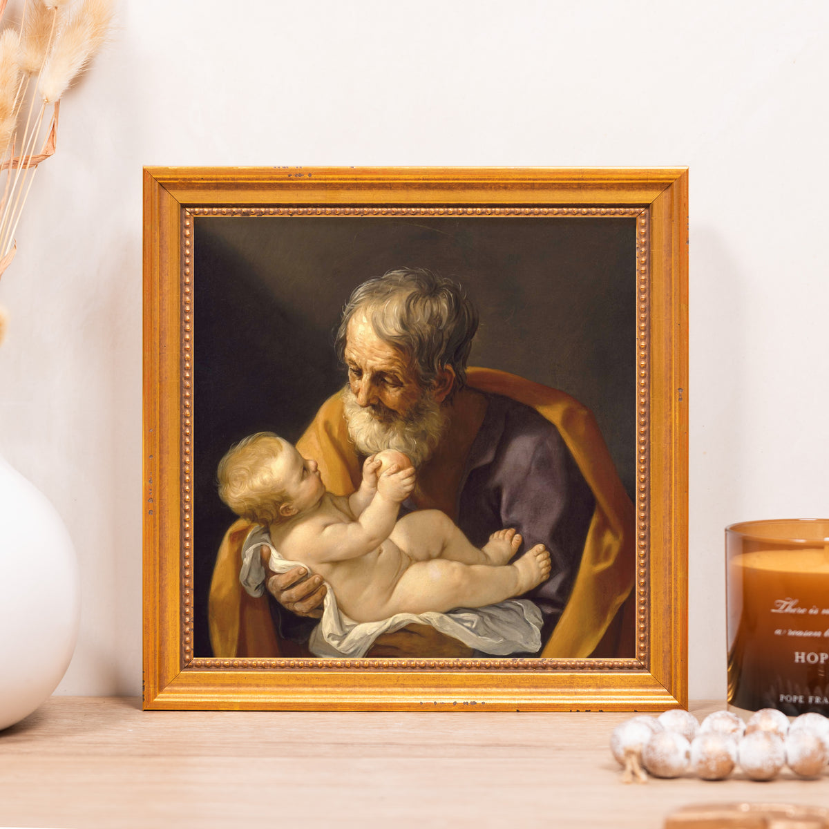 Framed art print of St Joseph and baby Jesus with ornate golden frame.