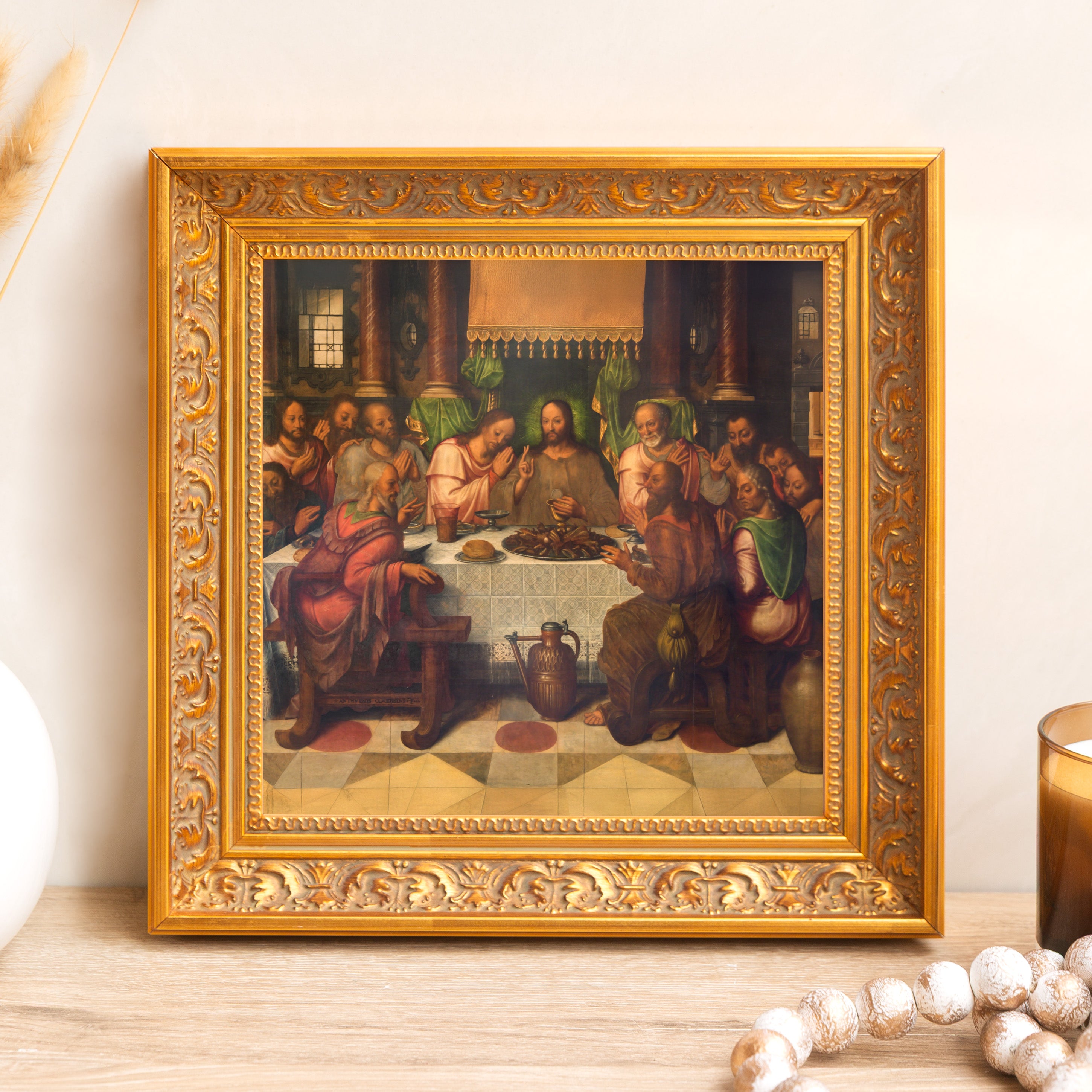 Framed painting depicting The Last Supper in an ornate gold frame hanging on a wall.