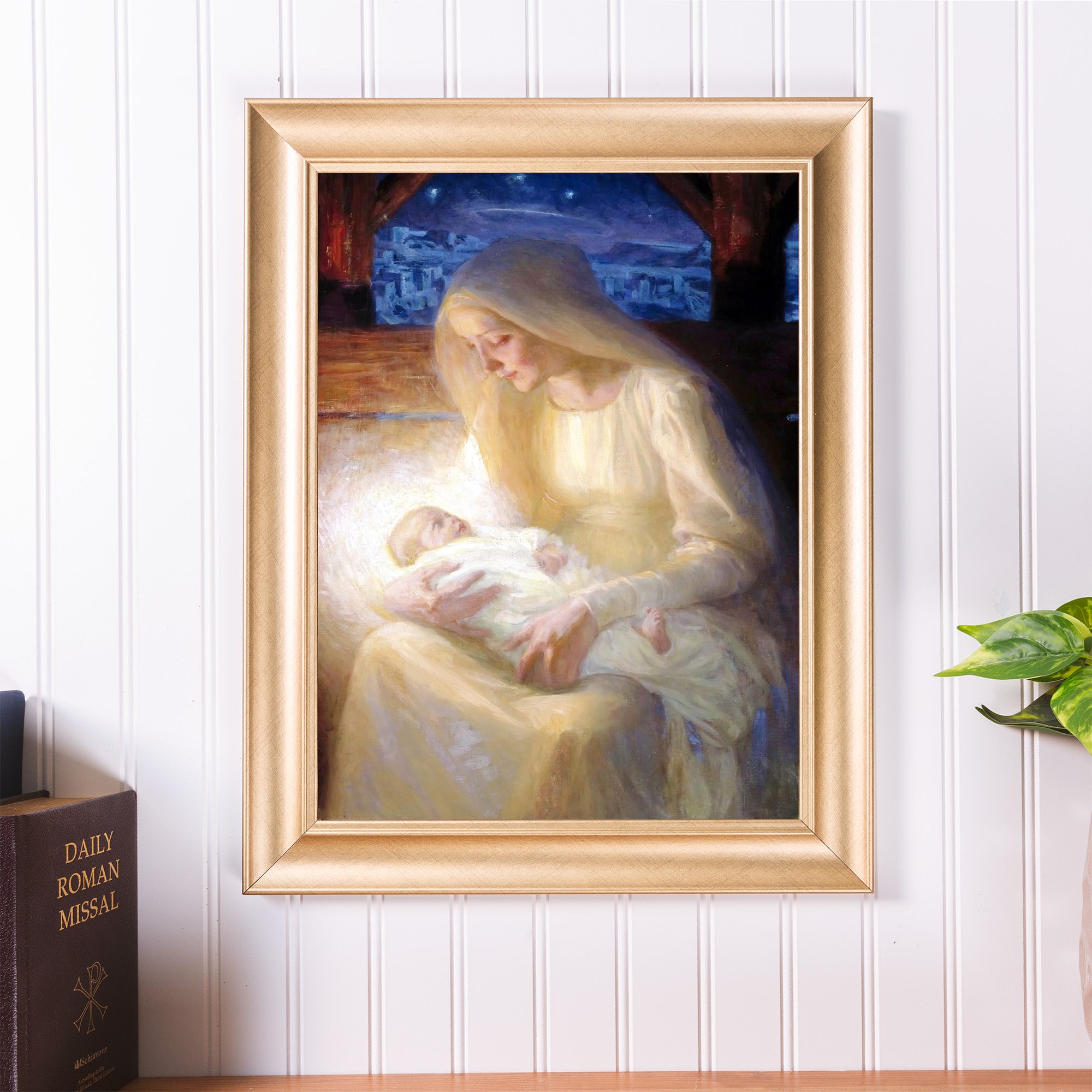 Framed painting of the Virgin Mary holding baby Jesus in her arms, featuring muted colors in a traditional style.