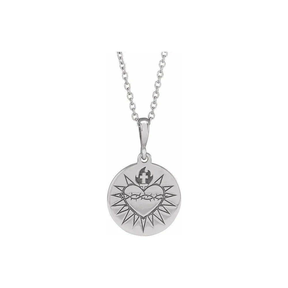 Silver necklace features a round pendant with a heart and crown of thorns design.