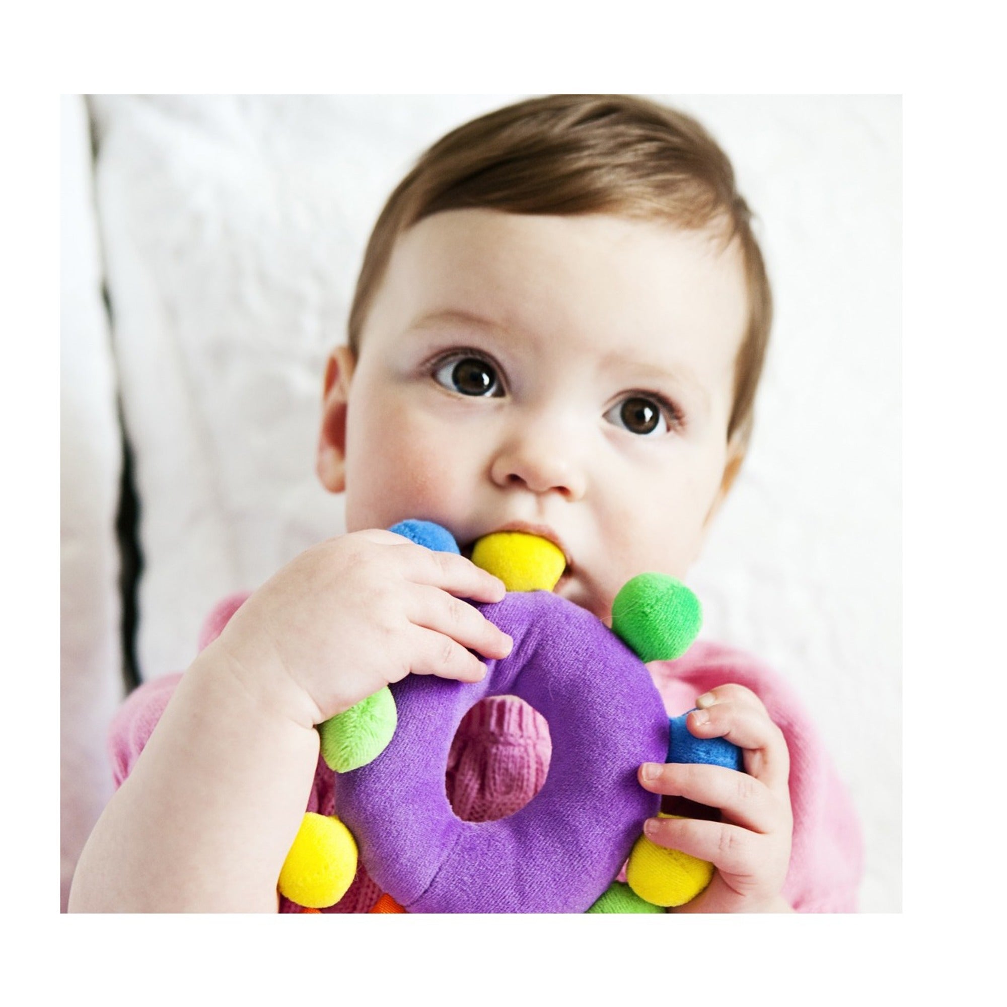 Baby teether. Purple fabric ring with colorful plush balls attached.