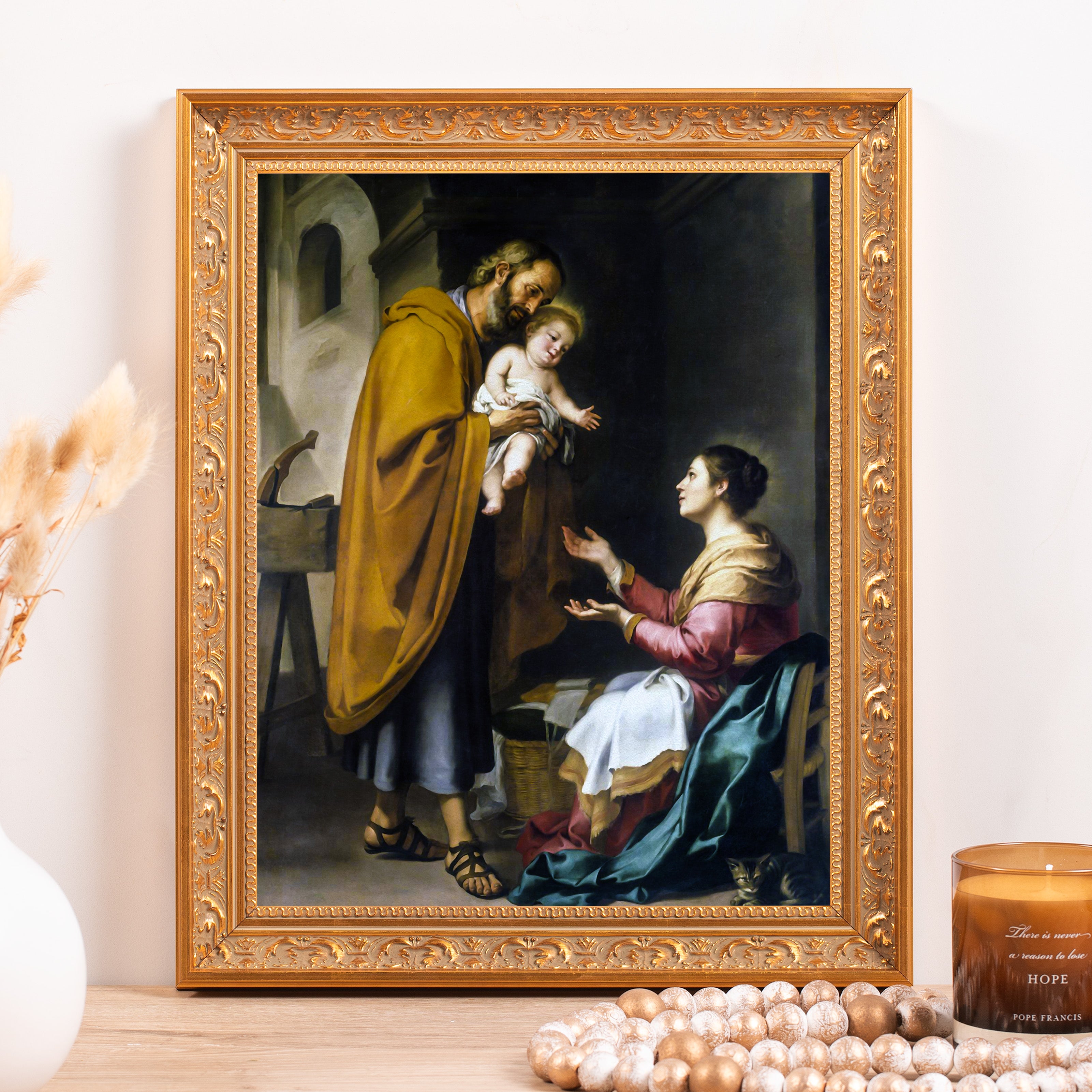 Framed art depicting Mary and Joseph with baby Jesus in ornate gold frame, hung on wall as decoration.