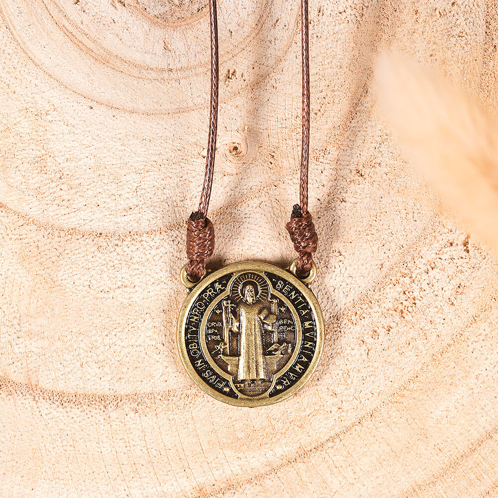 St. Benedict medal necklace; brass-tone pendant with brown cord.