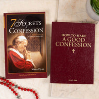 Two books on a marble surface, 7 Secrets of Confession, and How to Make a Good Confession, with rosary beads.
