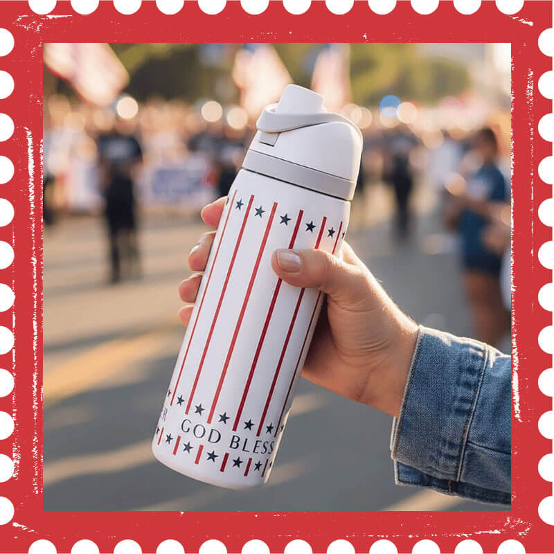 Hand holding a water bottle with stars and stripes and God Bless America on it.