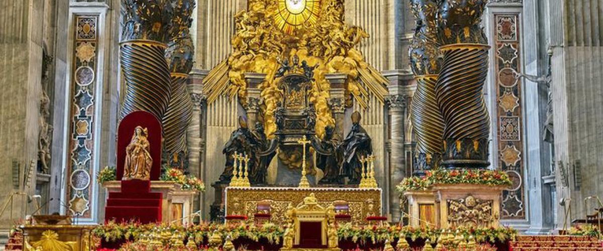 Ornate altar featuring St. Peter’s Chair with golden decorations, statues, tall marble columns, floral arrangements, and a radiant stained-glass window centerpiece.