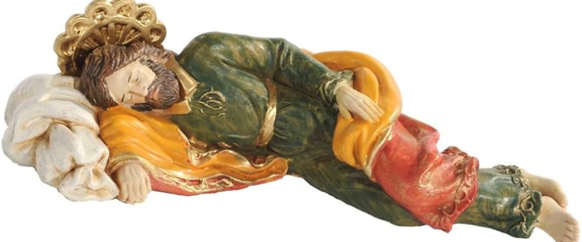 Sleeping St. Joseph statue resting on a note that reads ‘Please pray for me