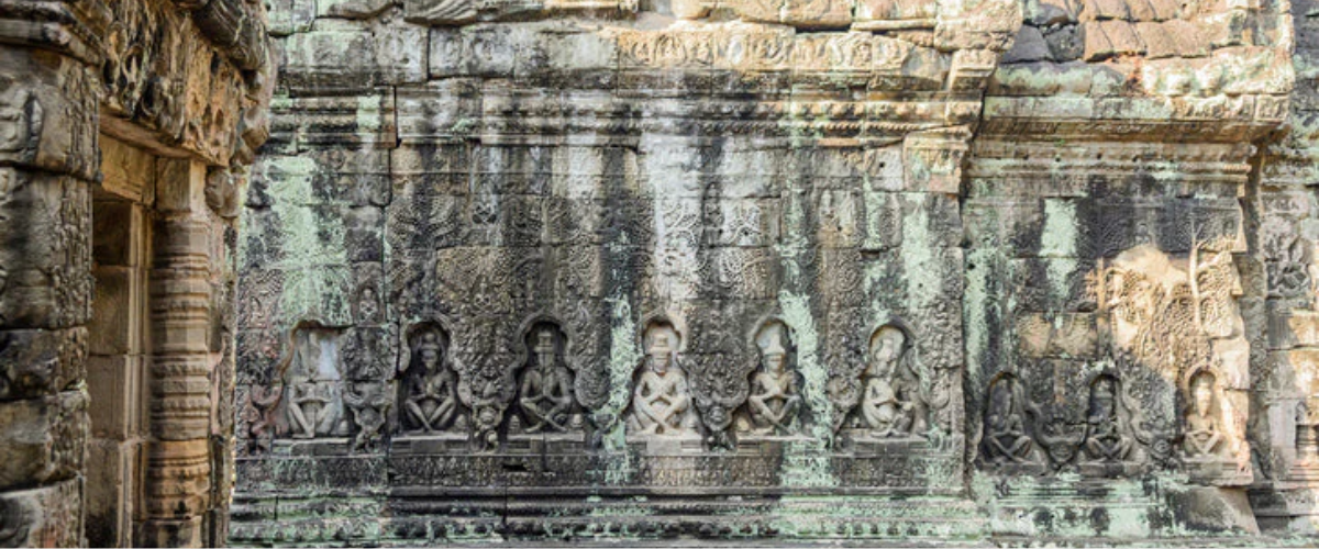 Ancient carved stone wall with seated figures, evoking Saint Francis of Paola