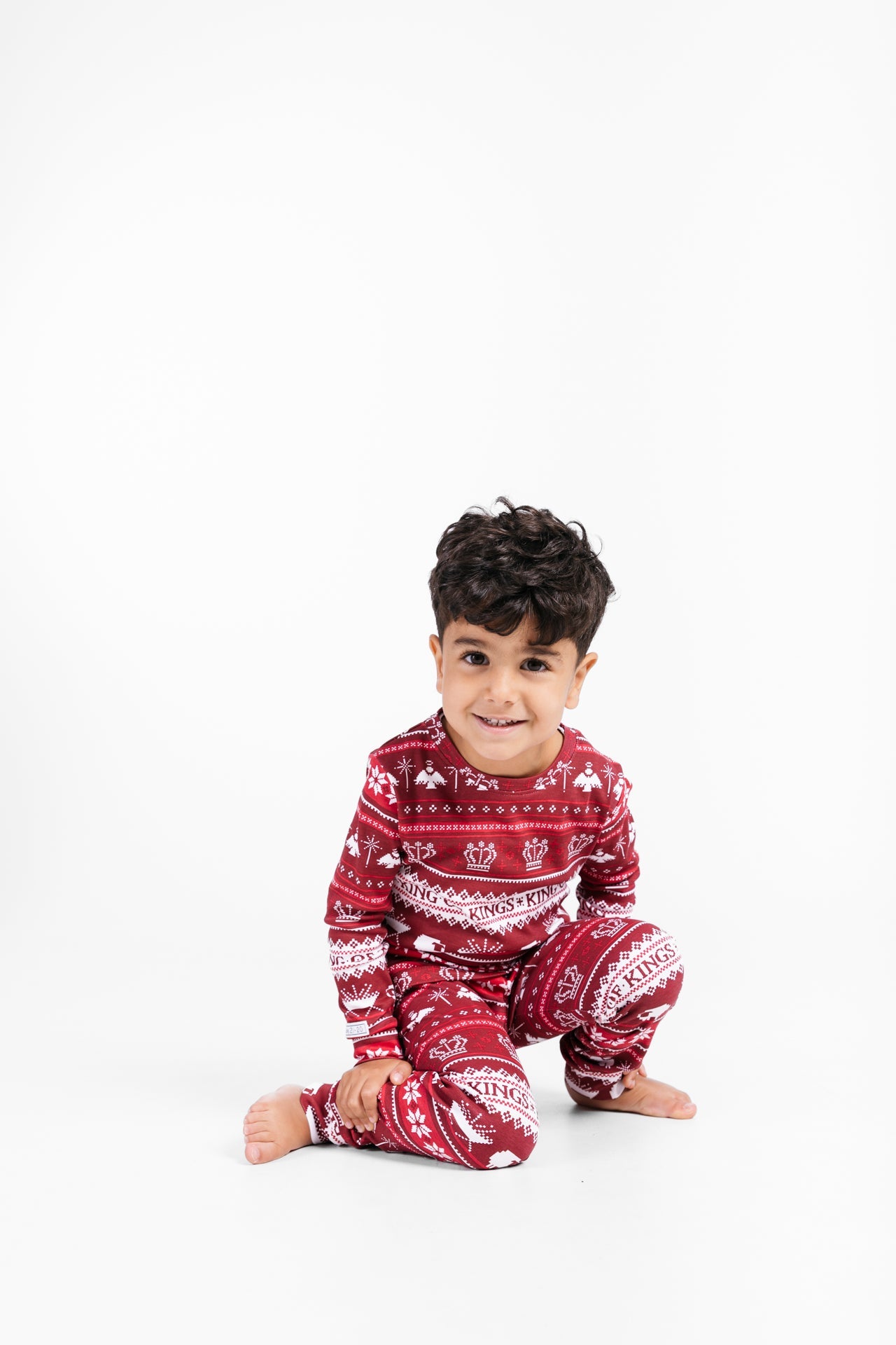Child's red knit pajamas with long sleeves, pants, and fair isle print.