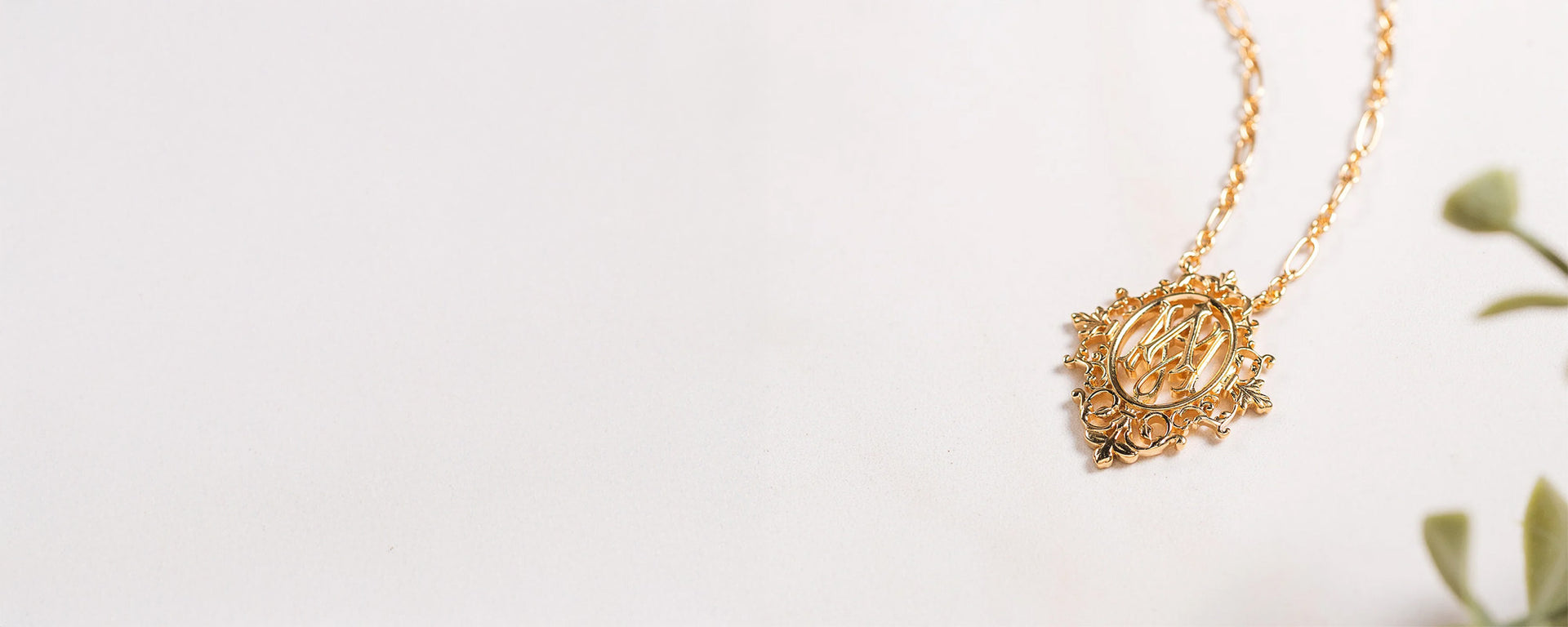 Gold Marian-style pendant necklace with ornate detailing on a light background.