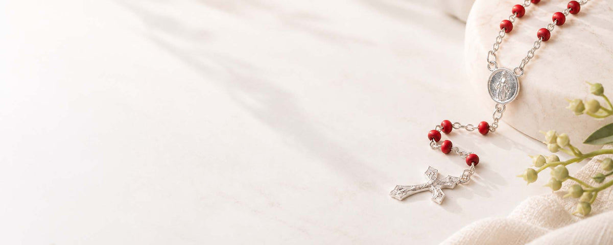 Red rosary on minimalist background with natural elements.