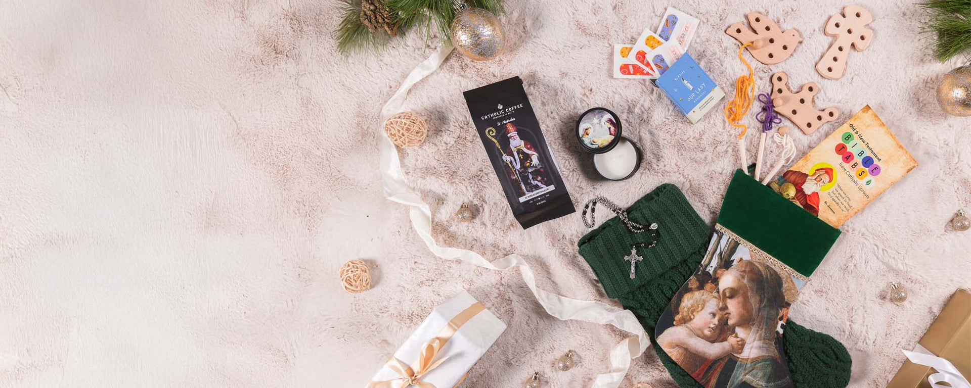 Christmas-themed gift arrangement featuring religious items, decorations, and a green stocking