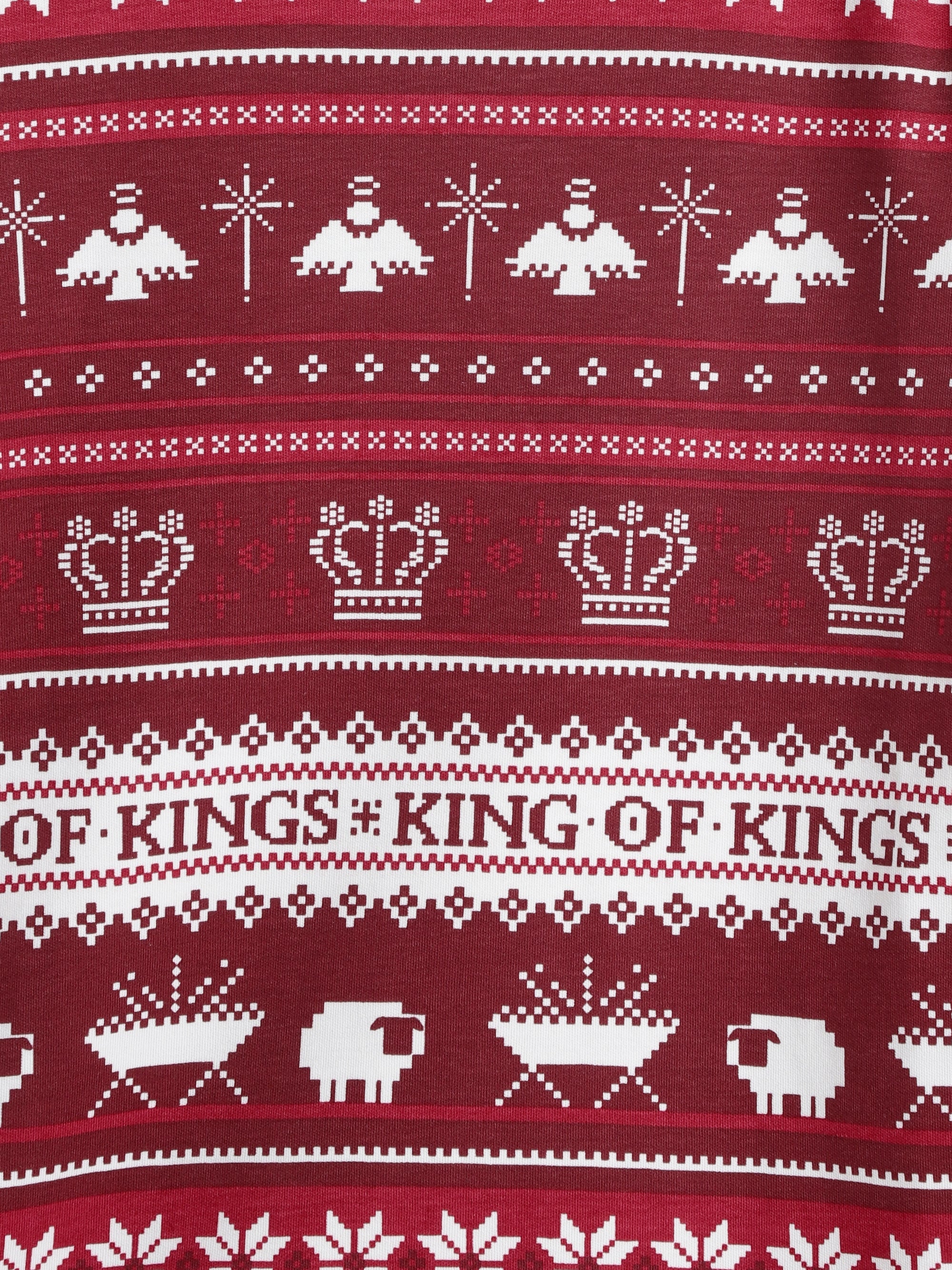 Burgundy textile with pixelated white nativity, angel, crown and snowflake Christmas sweater pattern.