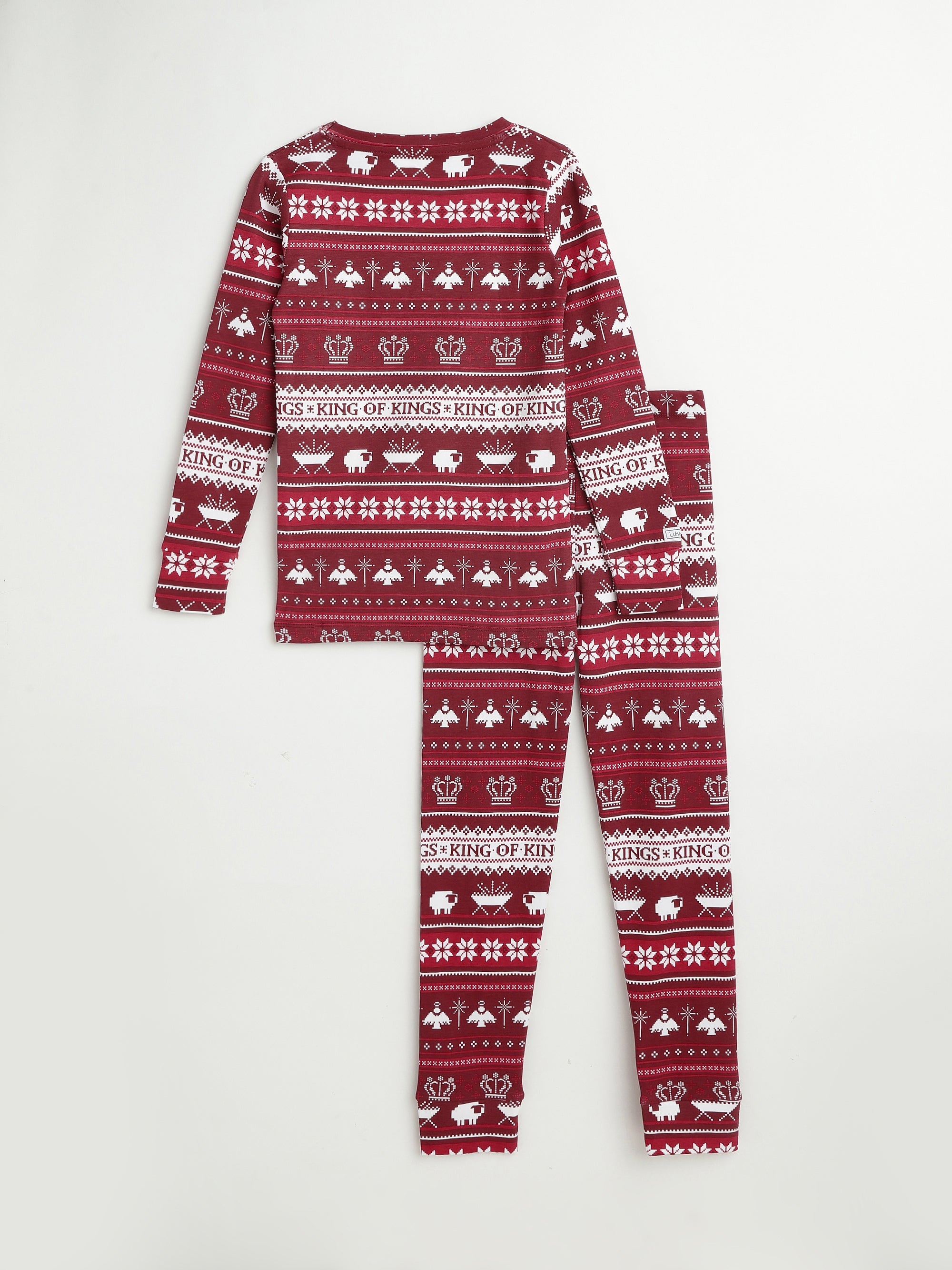 Christmas Pajamas in maroon, patterned with crowns, snowflakes, and nativity scenes in white.