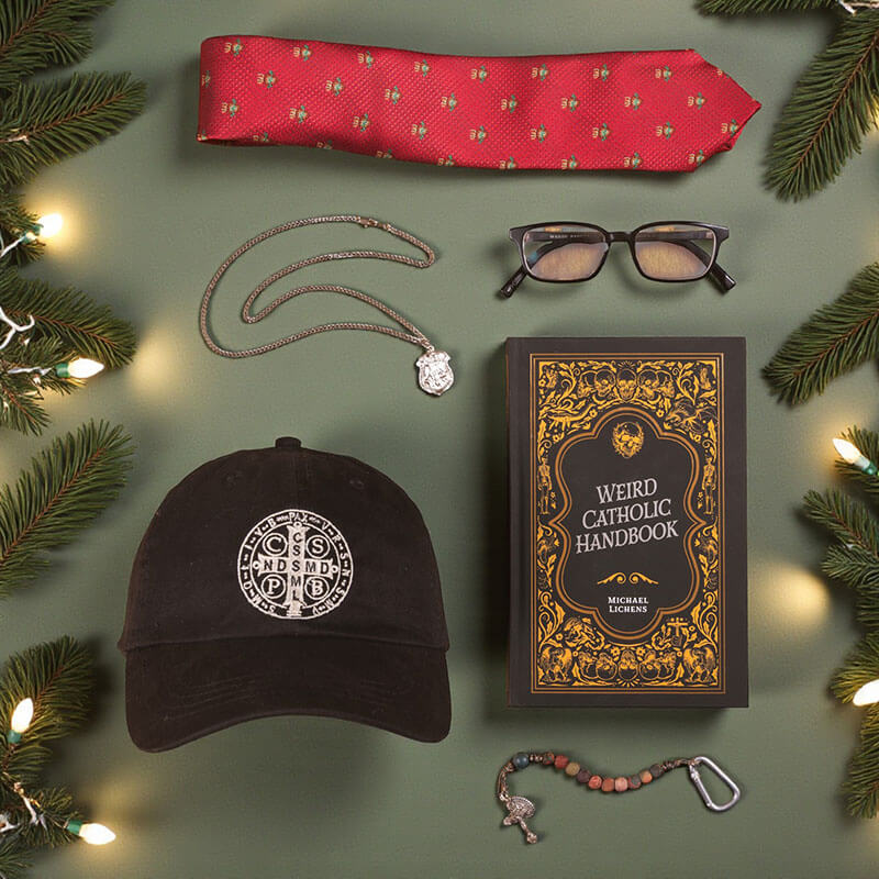 Collection of items including a red tie, black cap, necklace, glasses, and 'Weird Catholic Handbook' on a green background with Christmas decorations.