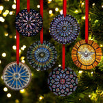 Decorative stained glass ornaments hanging on a Christmas tree with blurred lights in the background.
