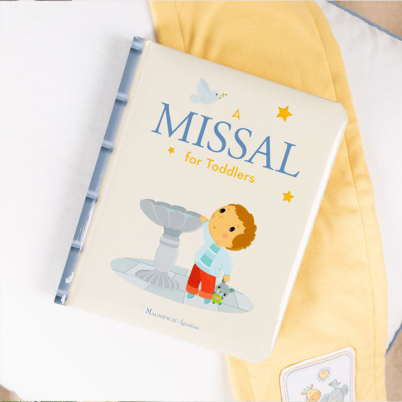 Book titled 'A Missal for Toddlers' with a child illustration on a yellow cushion.