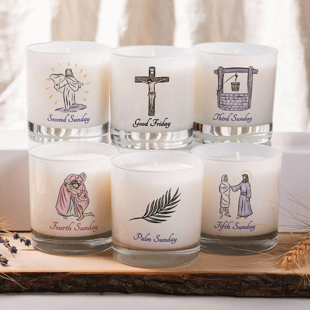 Set of six candles with religious illustrations and text on a wooden tray.