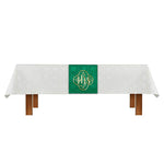 White tablecloth with a green and gold monogram on a white background.