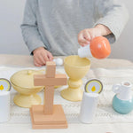Child playing with wooden toys on a light surface.