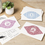 Decorative greeting cards with intricate designs on a wooden surface.